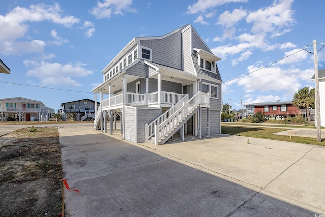 206 56th Ave N, North Myrtle Beach, SC 29582 - view of front facade with driveway, stairway, and a shingled roof