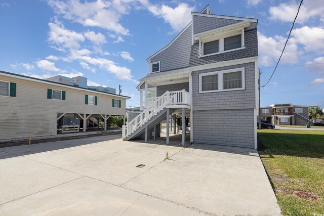 206 56th Ave N, North Myrtle Beach, SC 29582 - view of front of home featuring stairway, a shingled roof, and a front yard