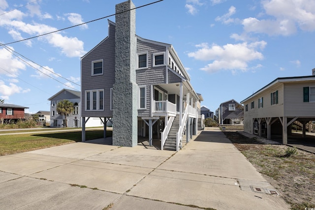 206 56th Ave N, North Myrtle Beach, SC 29582 - view of side of property featuring a residential view, driveway, stairway, and a porch