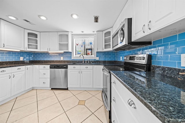 kitchen with white cabinets, appliances with stainless steel finishes, light tile patterned floors, and sink