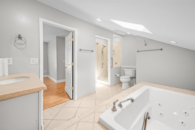 full bathroom featuring lofted ceiling with skylight, tile patterned flooring, vanity, and toilet