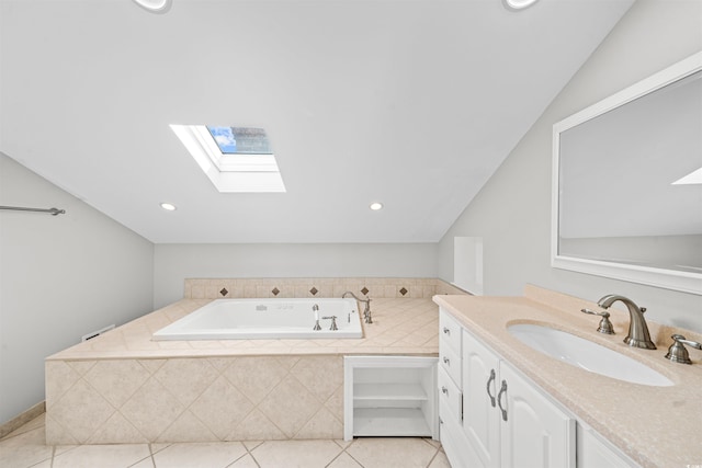 bathroom featuring tile patterned floors, vanity, vaulted ceiling with skylight, and a relaxing tiled tub