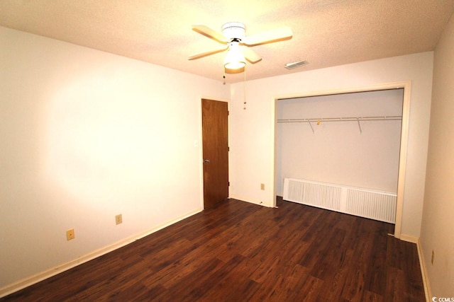 unfurnished bedroom featuring a closet, radiator heating unit, a textured ceiling, dark hardwood / wood-style floors, and ceiling fan