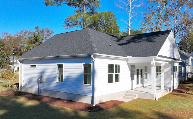 view of side of home with a lawn and covered porch