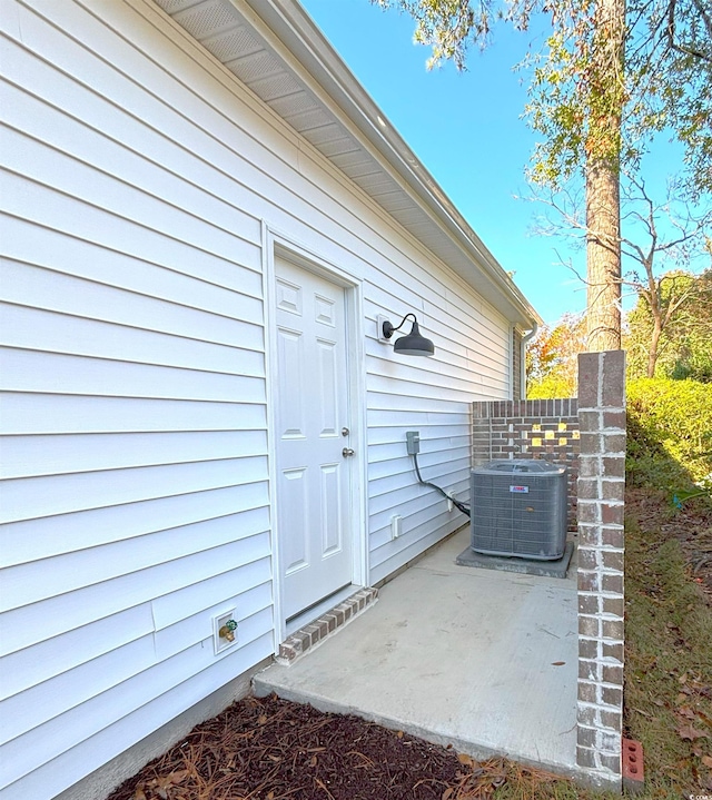 doorway to property with central air condition unit and a patio area