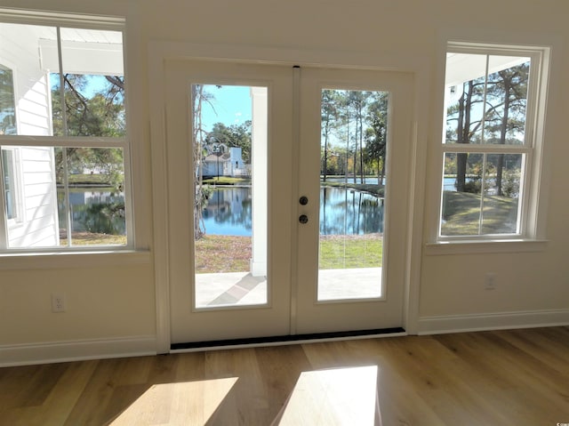 doorway to outside with plenty of natural light, a water view, and french doors