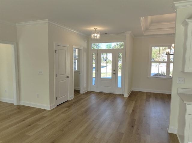 foyer entrance featuring crown molding, a chandelier, and light wood-type flooring