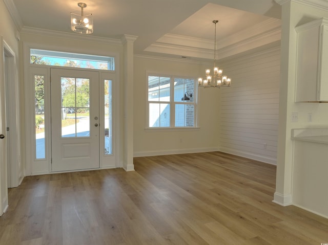 entryway featuring a wealth of natural light, wooden walls, light hardwood / wood-style floors, and a notable chandelier