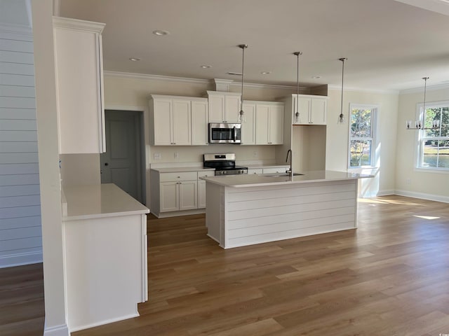 kitchen featuring white cabinetry, stainless steel appliances, wood-type flooring, decorative light fixtures, and ornamental molding