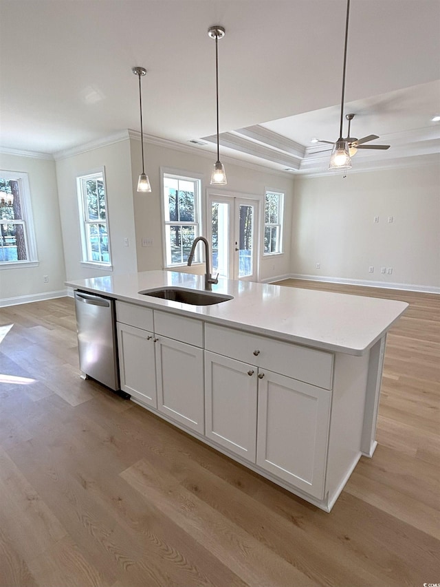 kitchen featuring white cabinets, a center island with sink, sink, stainless steel dishwasher, and light hardwood / wood-style floors