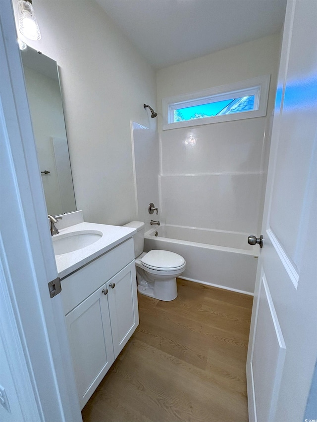 full bathroom with vanity, toilet, wood-type flooring, and shower / washtub combination