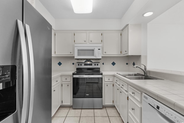 kitchen with tasteful backsplash, white cabinetry, sink, and stainless steel appliances