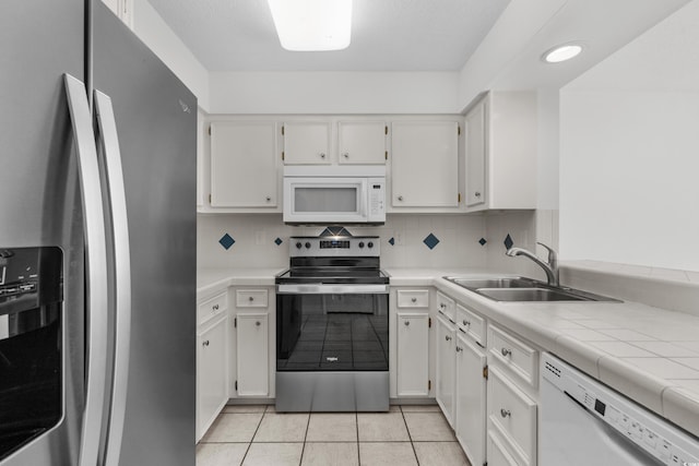 2925 Carriage Row Ln Unit 134, Myrtle Beach, SC 29577 - kitchen with stainless steel appliances, white cabinets, light tile patterned floors, and decorative backsplash