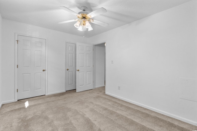 unfurnished bedroom featuring light carpet and ceiling fan