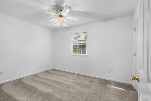 carpeted spare room with a textured ceiling and ceiling fan