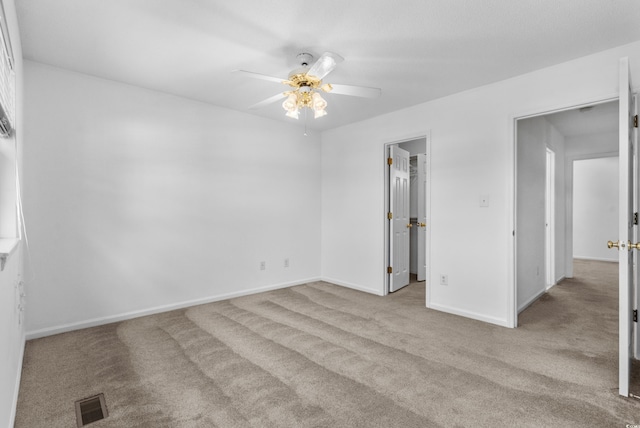 carpeted spare room featuring ceiling fan