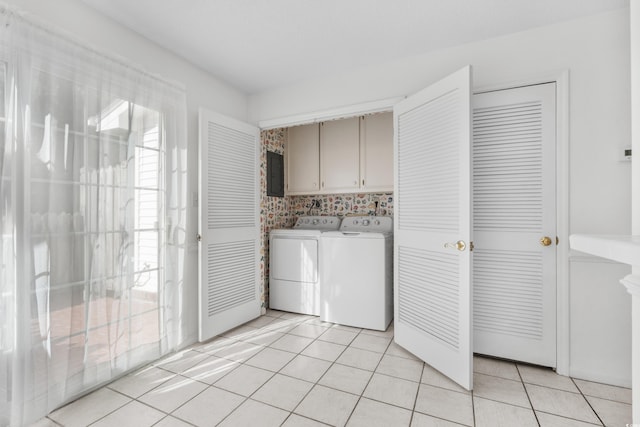 laundry room featuring cabinets, light tile patterned floors, electric panel, and washer and clothes dryer