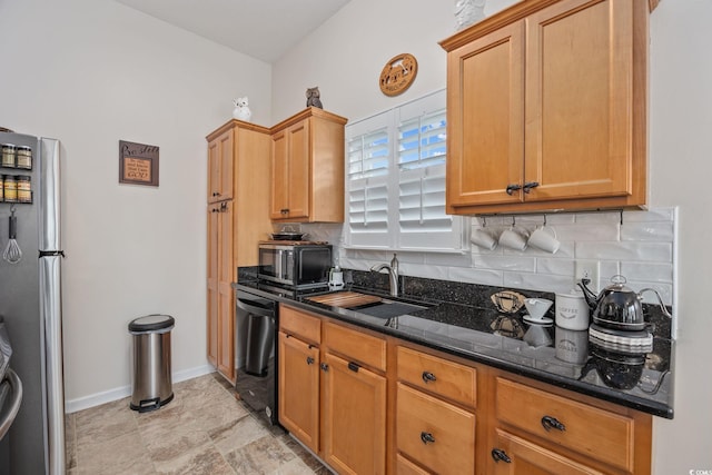 kitchen featuring tasteful backsplash, dark stone counters, sink, and black appliances