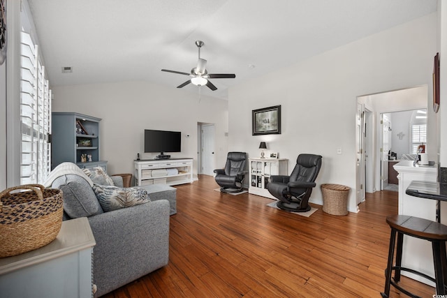 living room with lofted ceiling, wood-type flooring, and ceiling fan