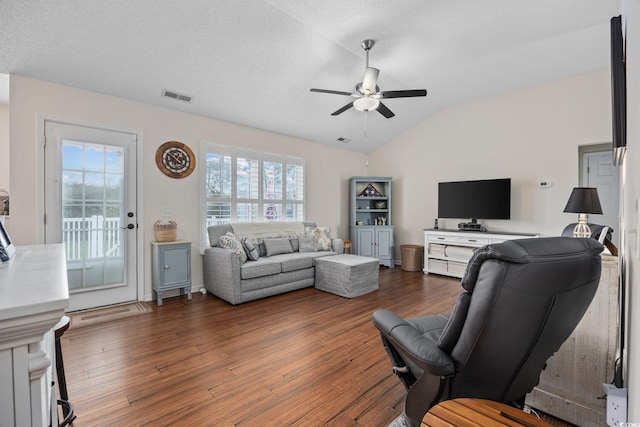 living room with dark hardwood / wood-style flooring, a textured ceiling, vaulted ceiling, and ceiling fan