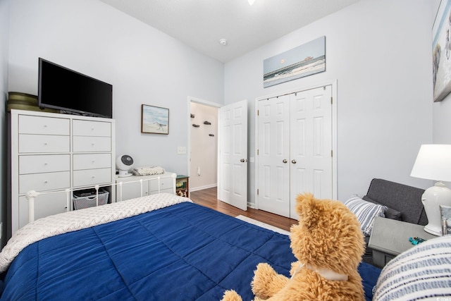 bedroom with dark hardwood / wood-style flooring and a closet