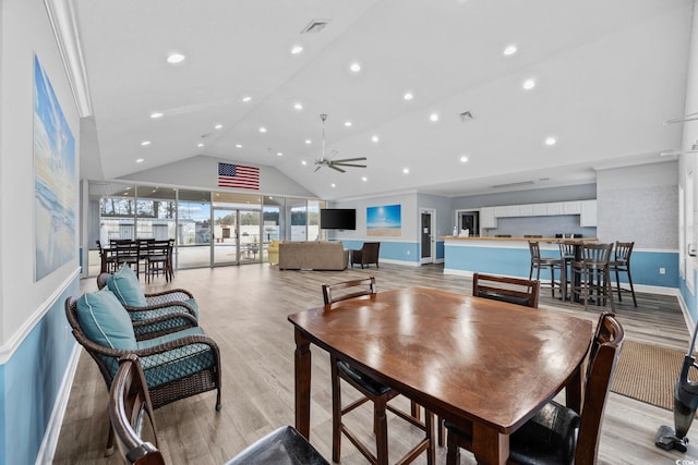 dining area with vaulted ceiling, ceiling fan, and light wood-type flooring