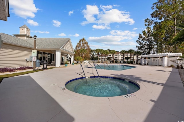 view of swimming pool with a patio, a pergola, and a community hot tub