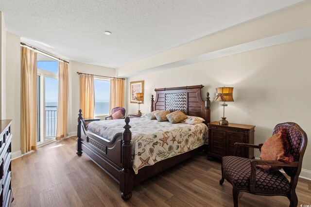 2709 Ocean Blvd S Unit 1202, Myrtle Beach, SC 29577 - bedroom featuring wood finished floors, a textured ceiling, and baseboards