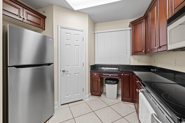 2709 Ocean Blvd S Unit 1202, Myrtle Beach, SC 29577 - kitchen featuring stainless steel appliances, light tile patterned flooring, and dark stone counters