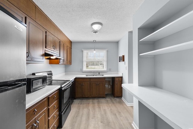 kitchen with pendant lighting, black range with electric stovetop, sink, light hardwood / wood-style flooring, and stainless steel fridge