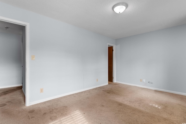 unfurnished room with carpet and a textured ceiling