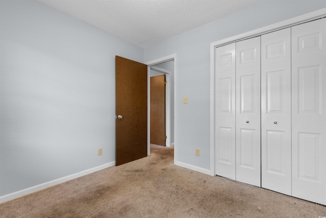 unfurnished bedroom with a closet, carpet floors, and a textured ceiling