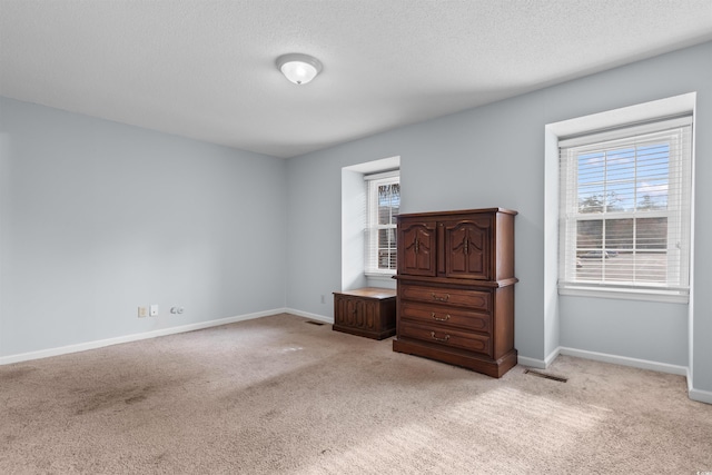 unfurnished bedroom with light carpet and a textured ceiling