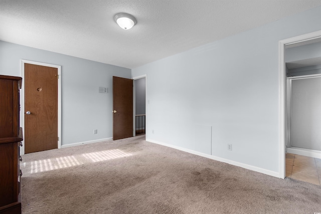 unfurnished bedroom with light colored carpet and a textured ceiling