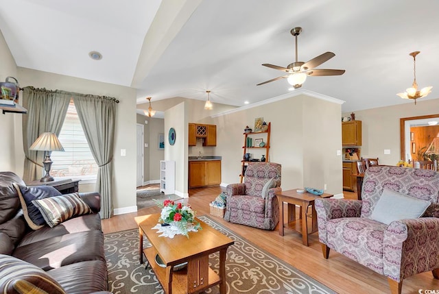 living room with ornamental molding, ceiling fan, and light hardwood / wood-style flooring