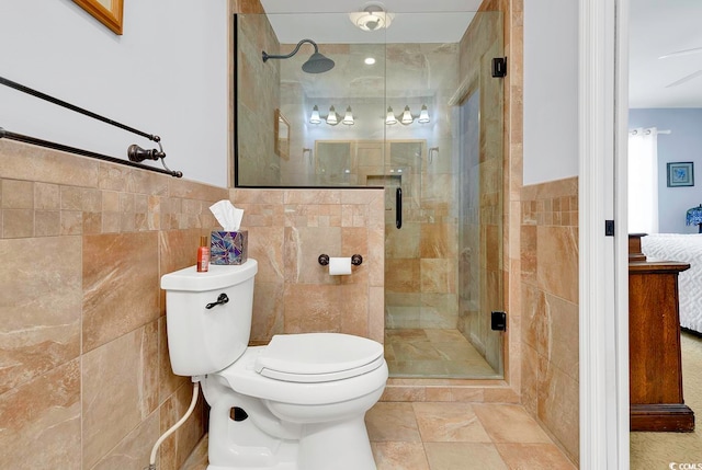 bathroom featuring toilet, an enclosed shower, and tile walls