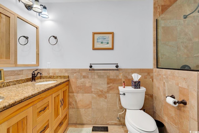 bathroom with vanity, toilet, and tile walls