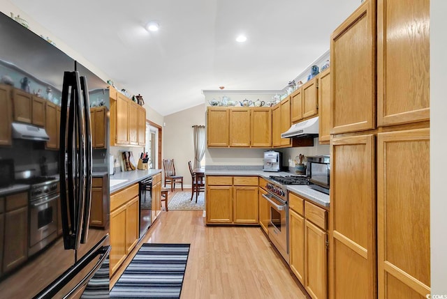 kitchen featuring light wood-type flooring, black appliances, lofted ceiling, and beverage cooler