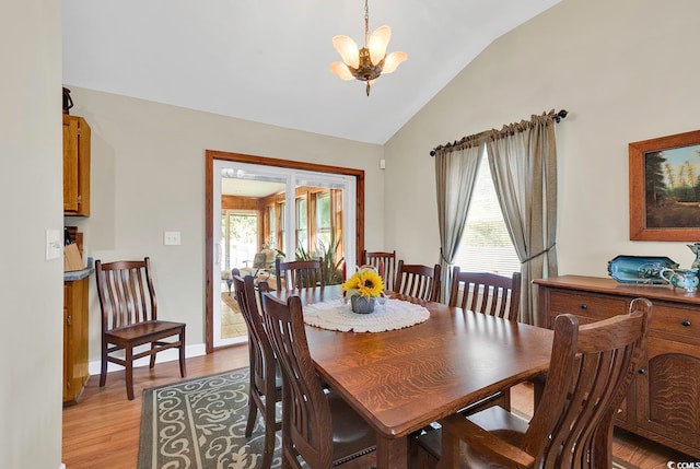 dining space featuring light wood-type flooring, lofted ceiling, and a notable chandelier