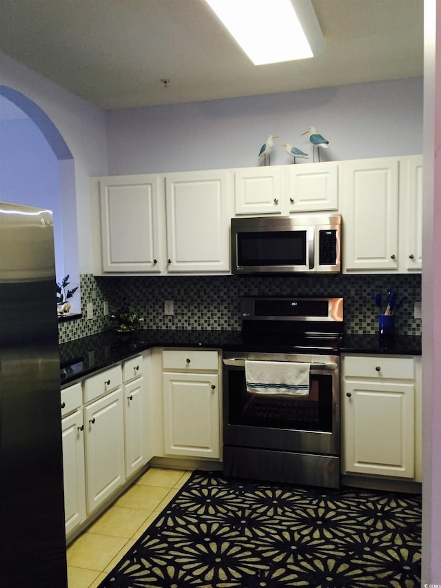 kitchen featuring white cabinets, light tile patterned floors, and stainless steel appliances