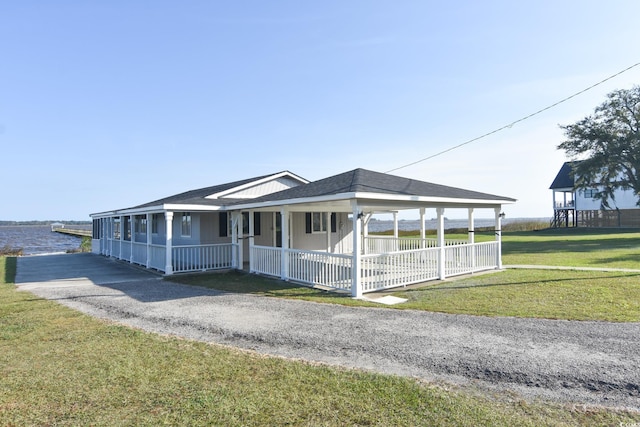 farmhouse-style home with a carport, a water view, and a front lawn