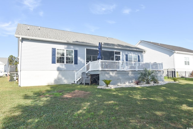 back of property with a wooden deck and a lawn