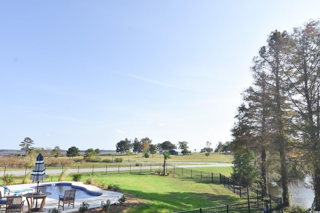 view of yard with a rural view, a fenced in pool, and a patio area