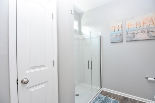 bathroom with hardwood / wood-style flooring and a shower with shower door