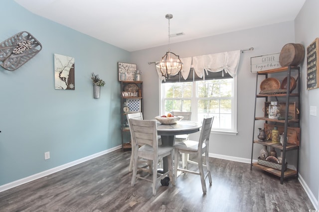 dining space featuring dark wood-type flooring and a chandelier