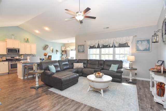 living room featuring ceiling fan, dark hardwood / wood-style floors, and vaulted ceiling