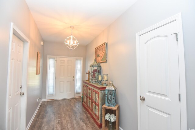 foyer with dark wood-type flooring and a notable chandelier