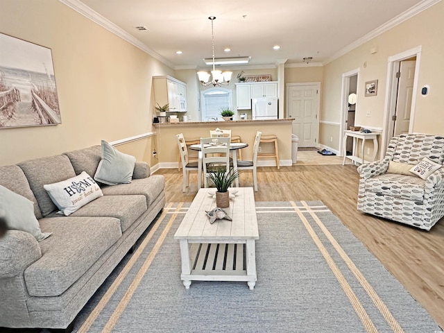 living room featuring light hardwood / wood-style floors, an inviting chandelier, and ornamental molding