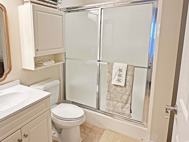 bathroom with toilet, vanity, tile patterned floors, and a shower with door