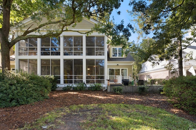 back of property with a sunroom